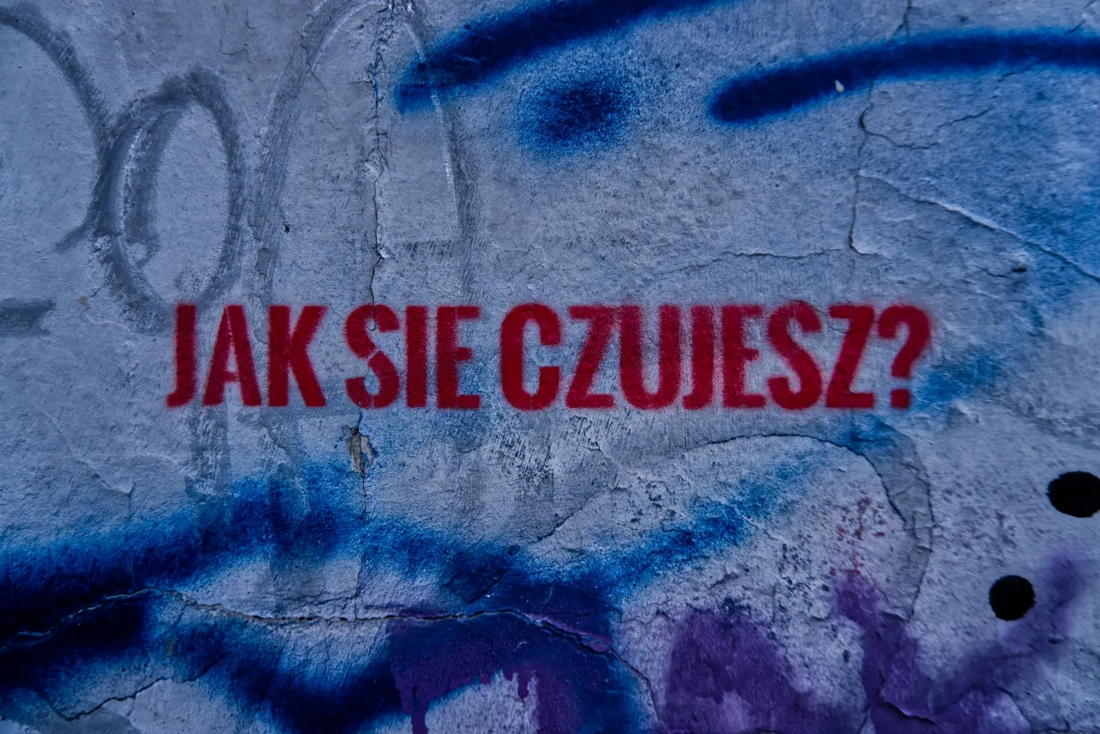 Zdjęcie napisu graffiti wykonanego przy pomocy szablonu. Tekst głosi "Jak się czujesz?".
